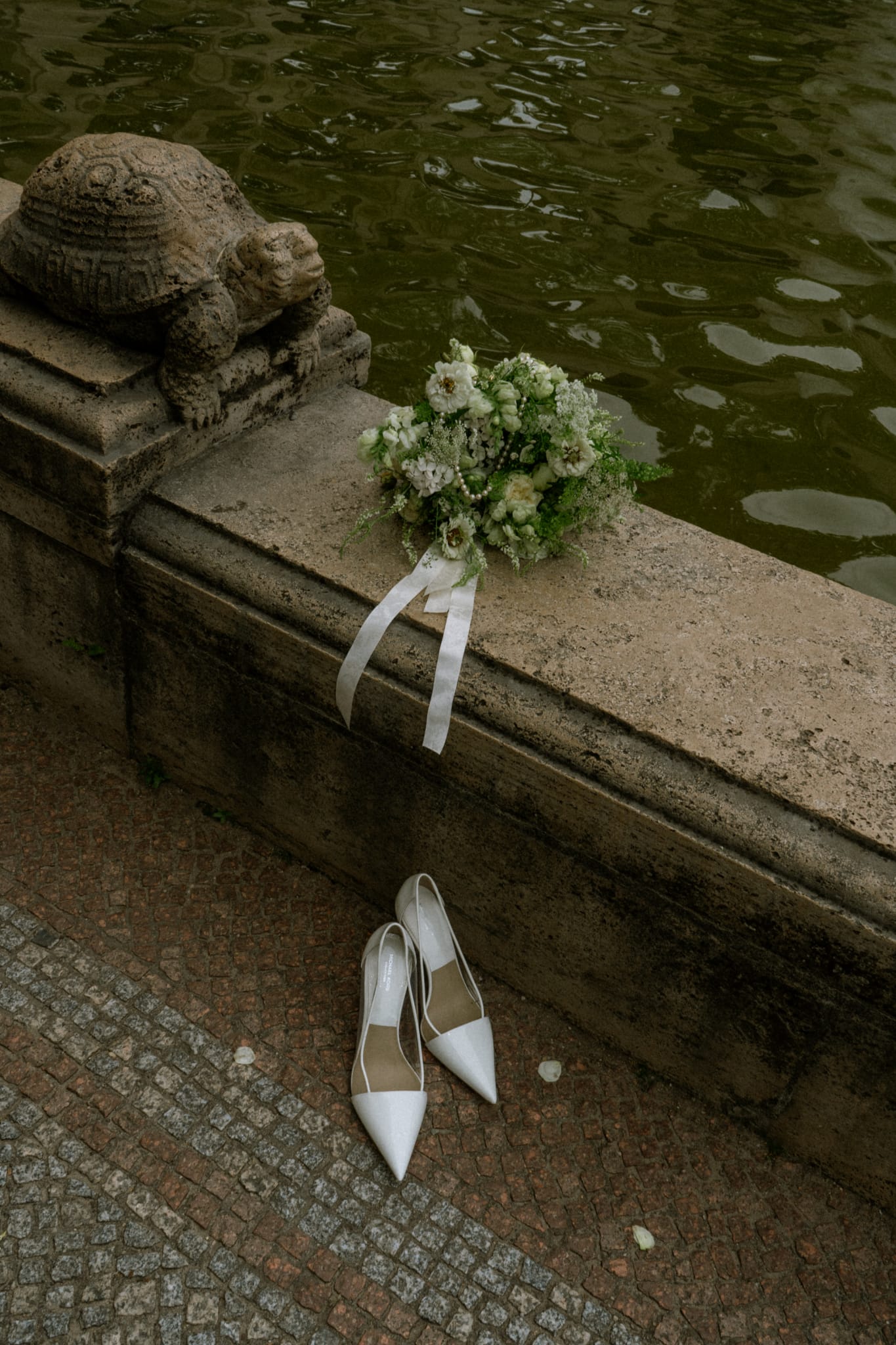 Brautstrauß und Brautschuhe am Wasser